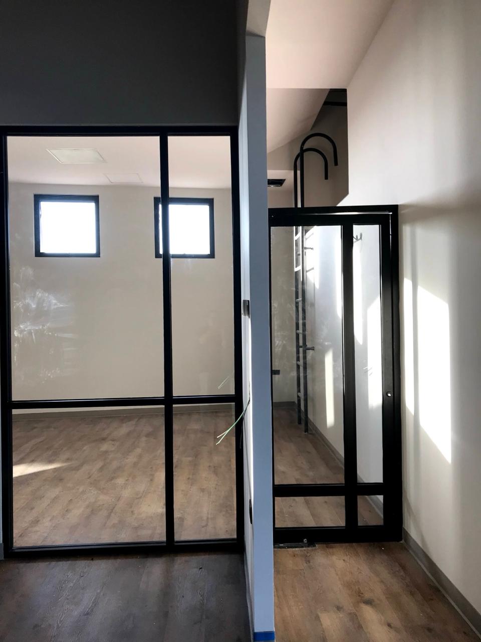 Cancelería de acero negro con vidrio en oficinas remodeladas
