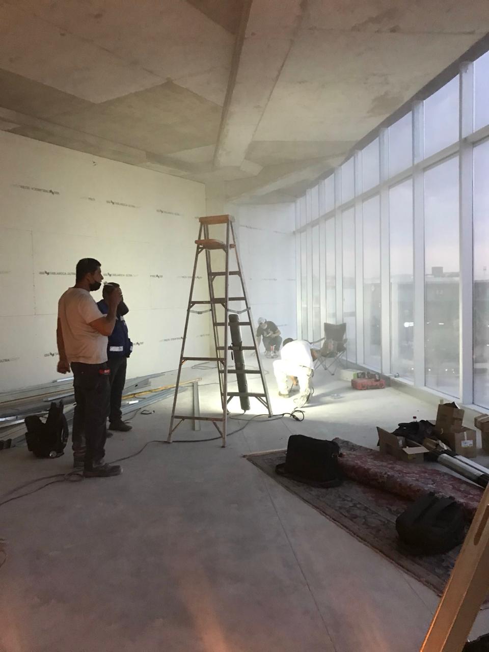 Supervisión de acabados en piso de duela frente a ventanales