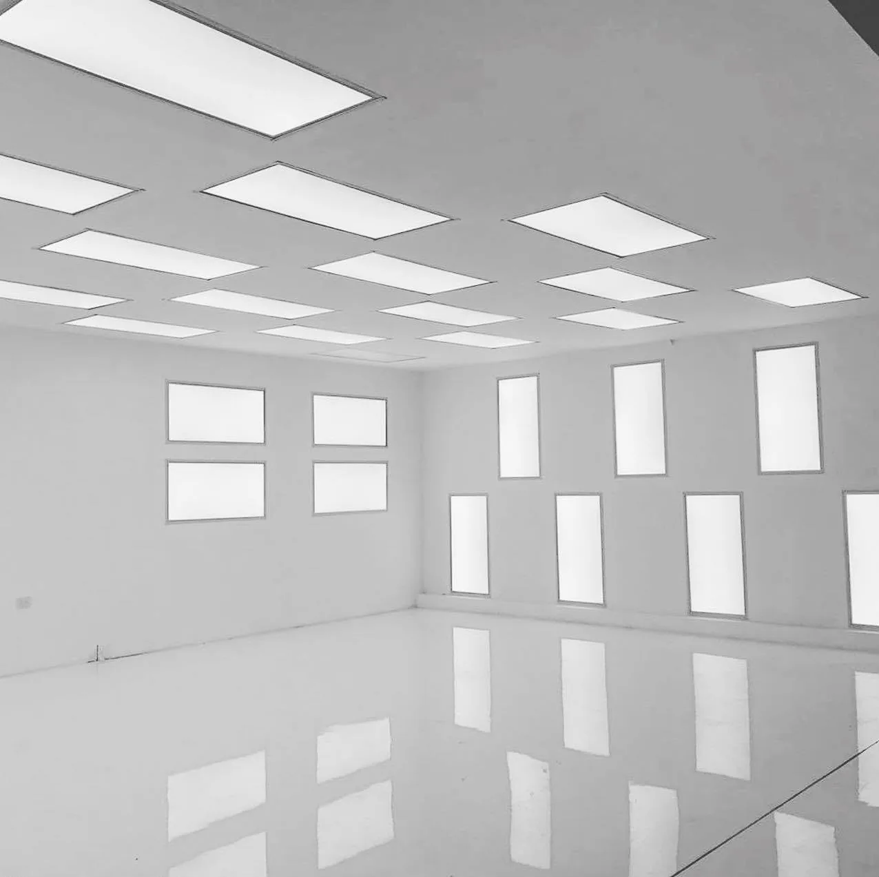 Piso epóxico terminado reflejando el plafón luminoso del área